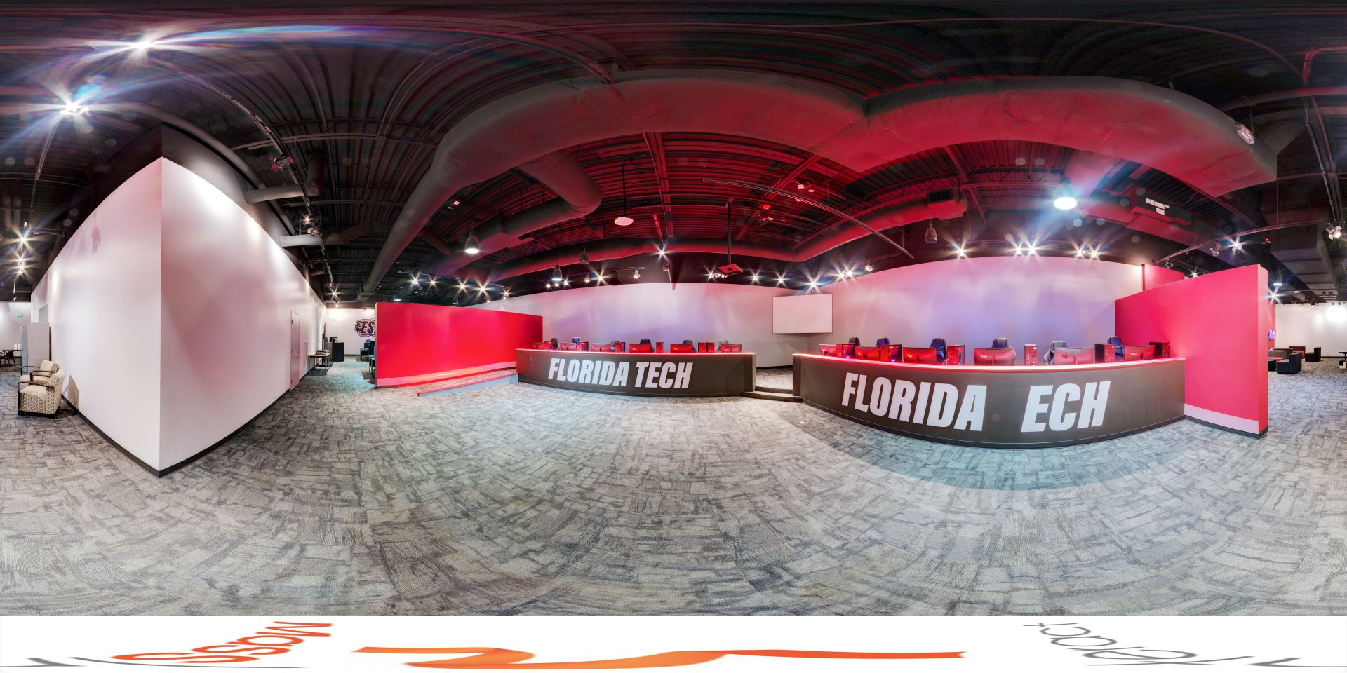 Panoramic view of the Florida Tech Esports center stage with gaming stations and red and white deco